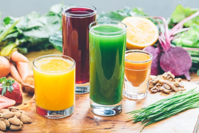 Colorful juices with an assortment of raw ingredients